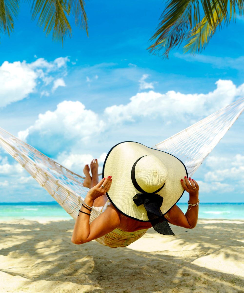 Woman,Relaxing,At,The,Beach,On,A,Hammock